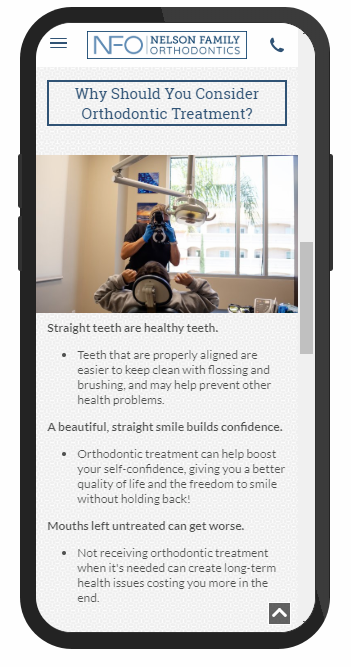 A phone screen shows a dentist examining a patient 's teeth.