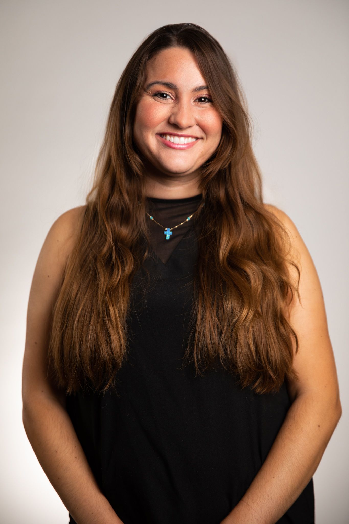 A woman with long hair is smiling for the camera