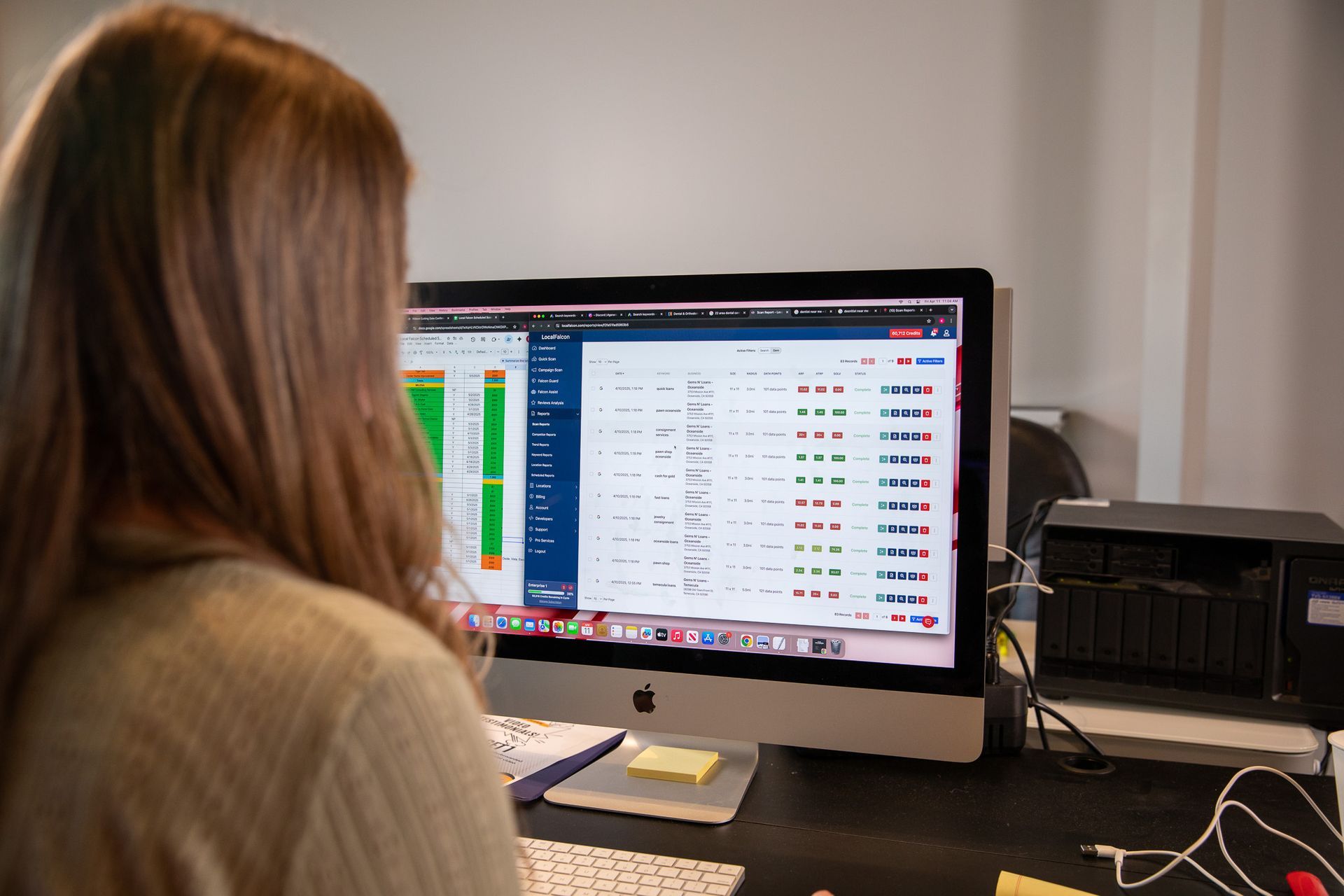 Person viewing a desktop monitor with a spreadsheet or dashboard in an office setting