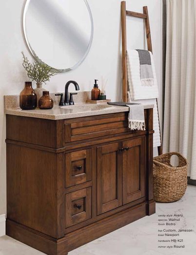 Bathroom vanity with wood cabinet, round mirror, and ladder with towel; neutral color scheme.