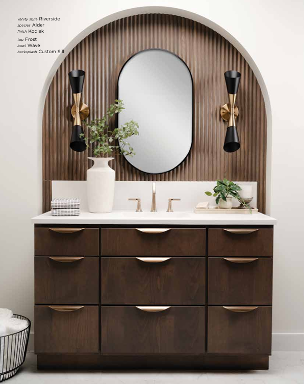 Dark wood bathroom vanity with a mirror, sconces, and white countertop.
