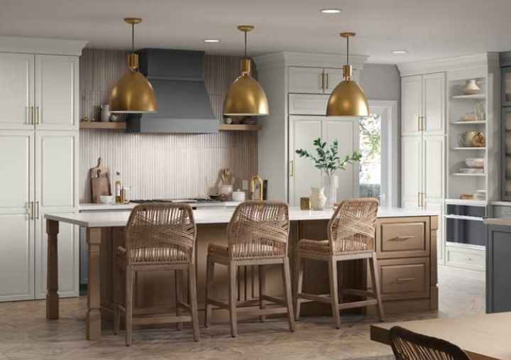 Kitchen with light cabinets, wood island, gold pendant lights, and woven bar stools.
