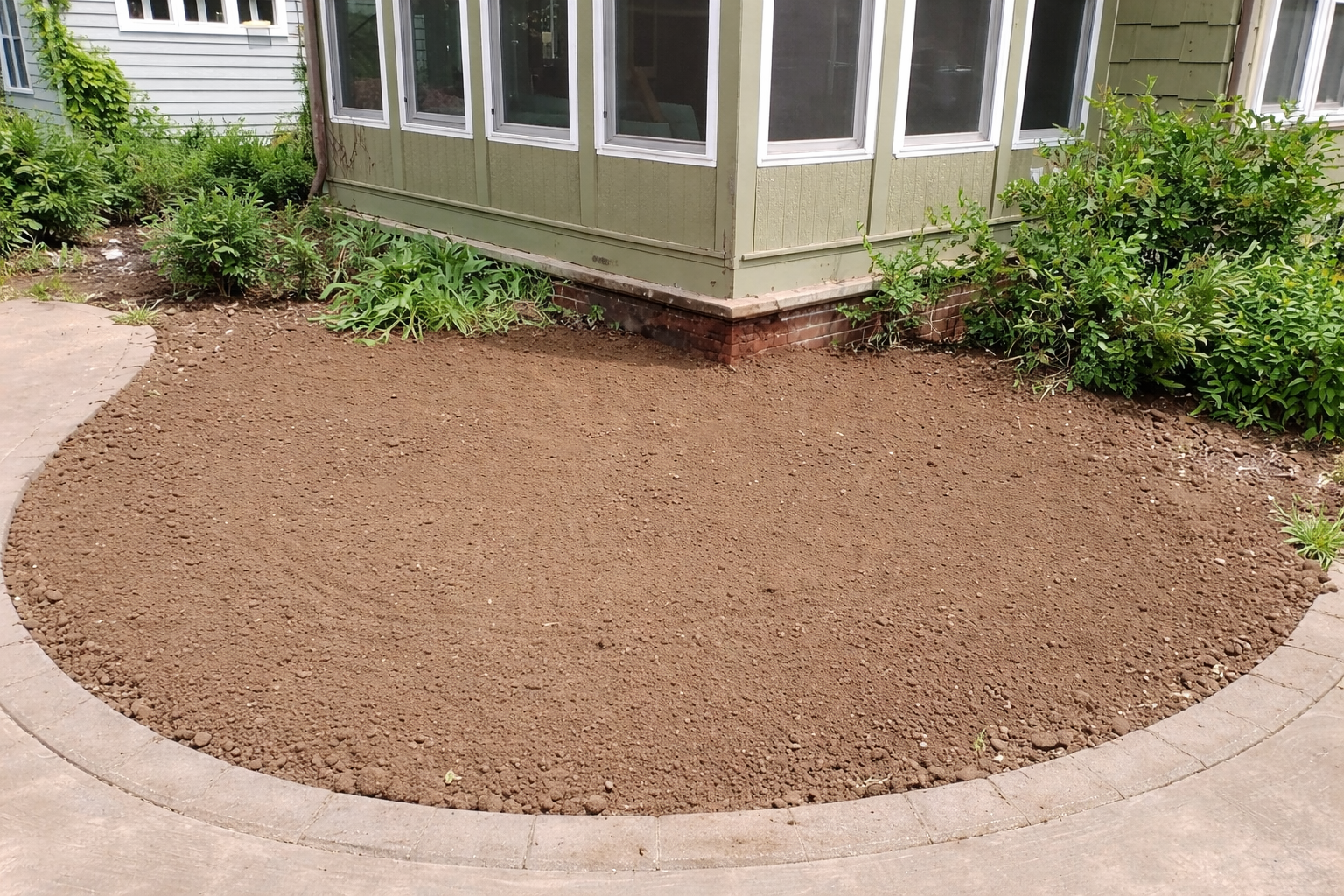 A yellow stump grinder machine works on a tree stump, creating a pile of wood chips in a grassy, outdoor setting.