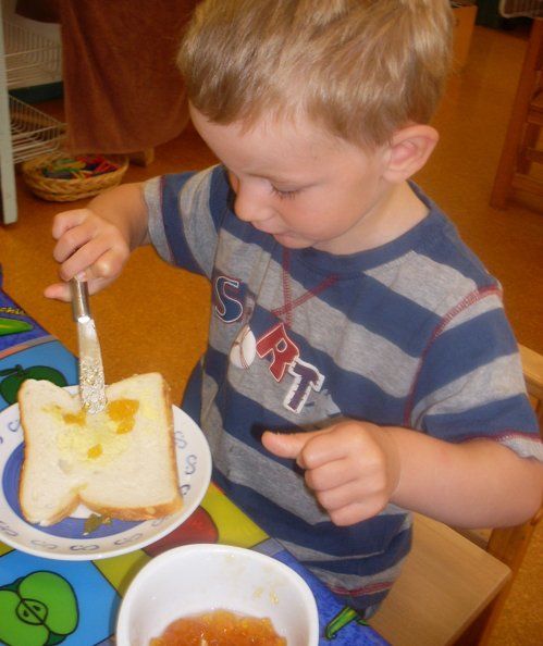 Kid applying butter on bread