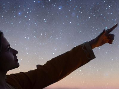 Image showing young woman stargazing, pointing at a star