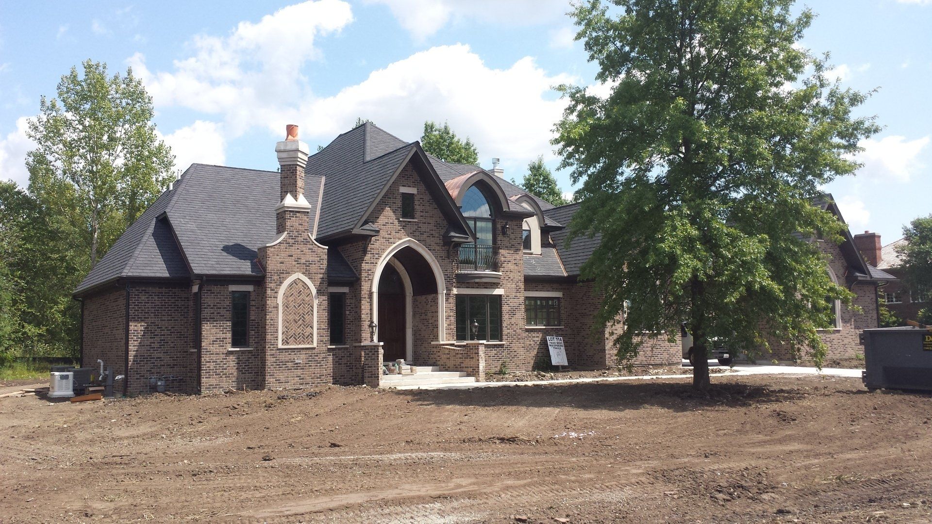 A large brick house with a tree in front of it