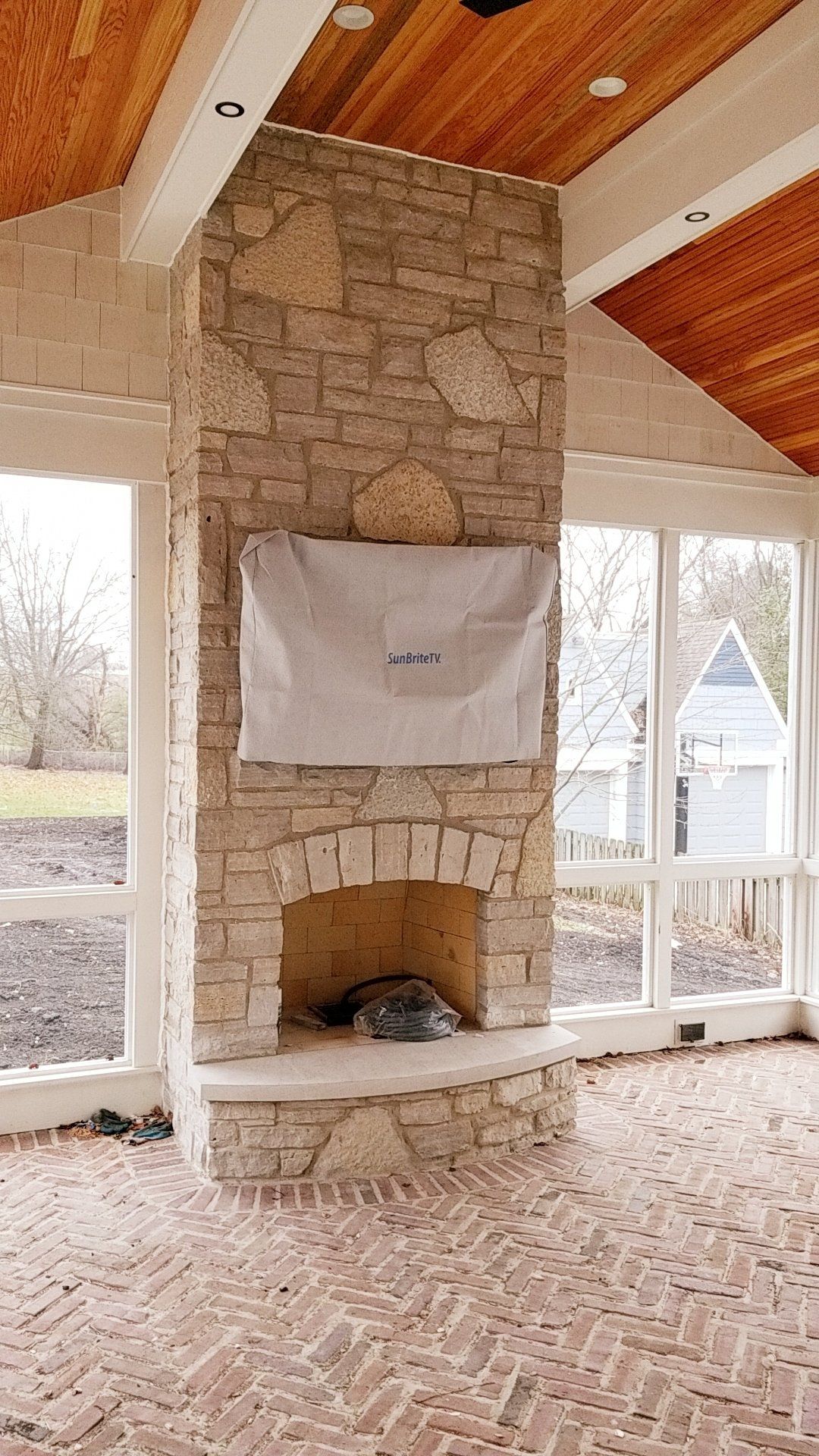 There is a stone fireplace in the middle of the room.