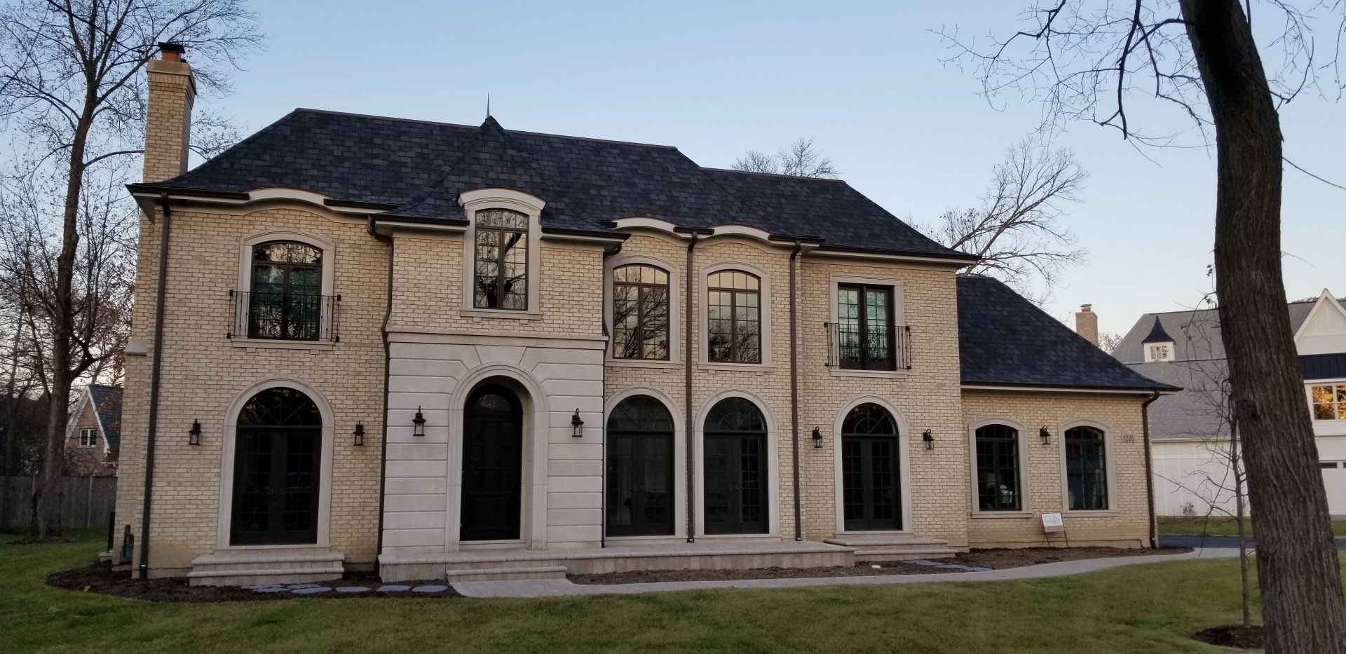 A large brick house with arched windows and a black roof