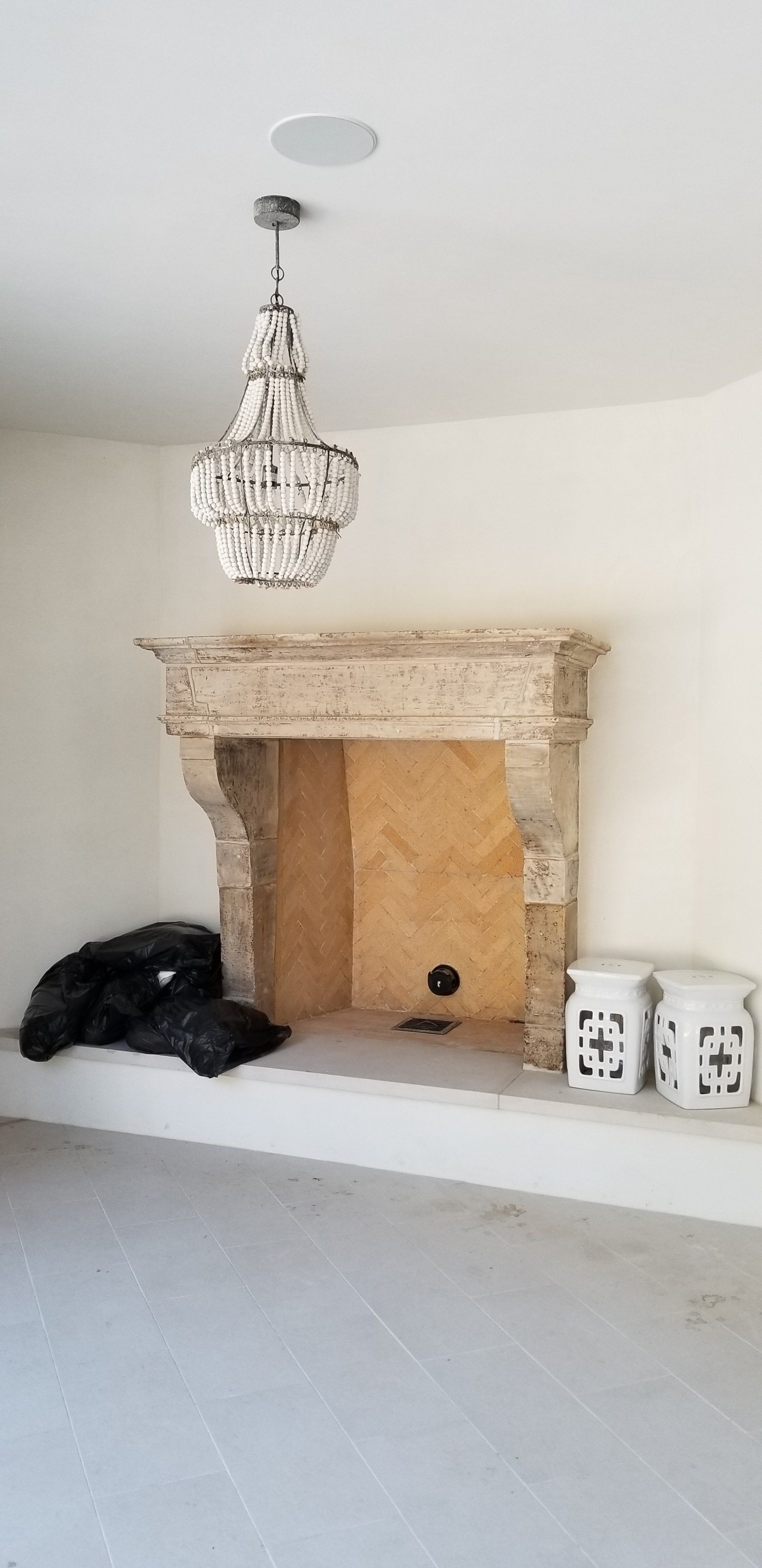 A living room with a fireplace and a chandelier hanging from the ceiling.