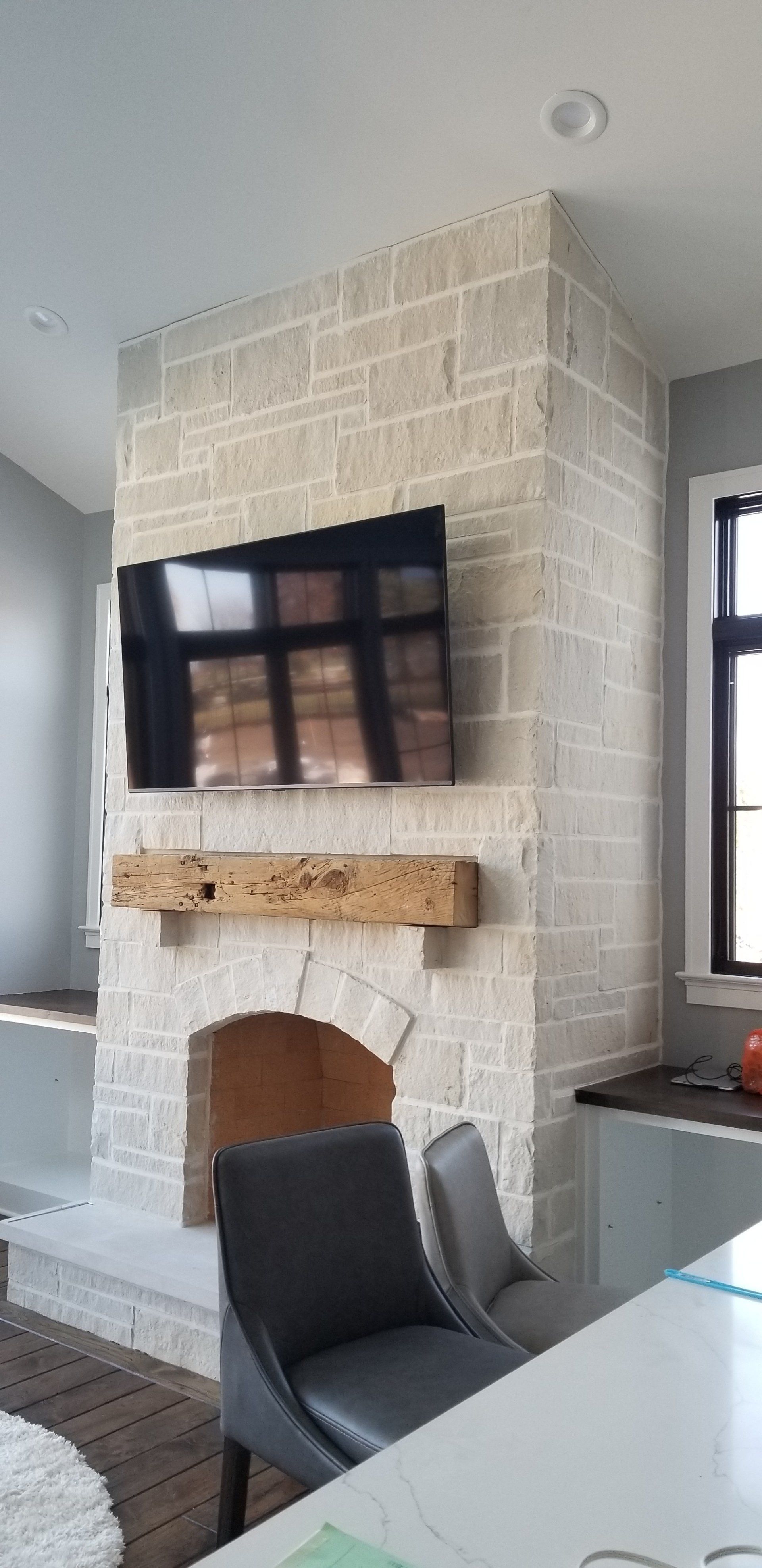 A living room with a fireplace and a flat screen tv mounted on the wall.