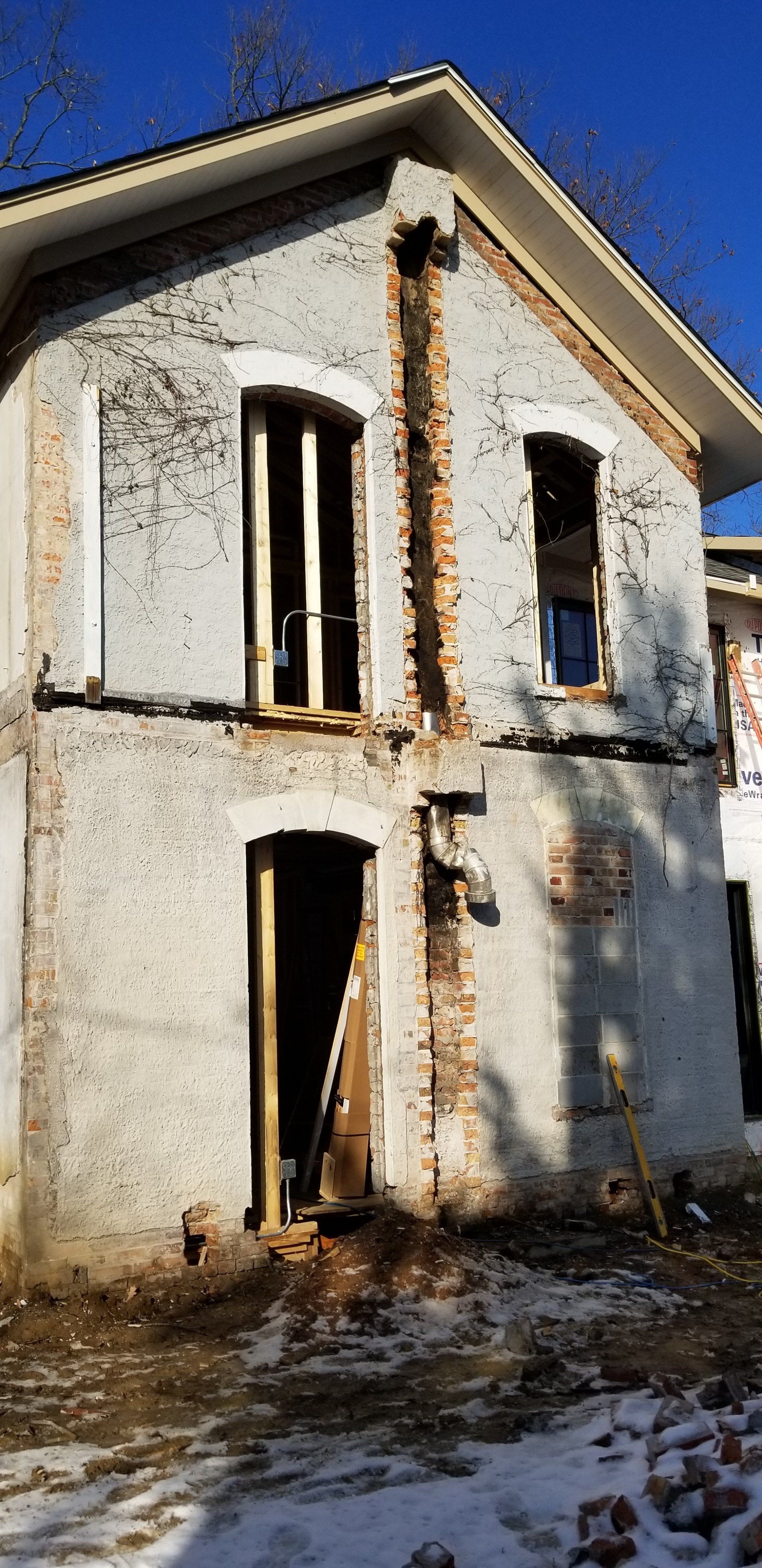 A large white brick building is being demolished.