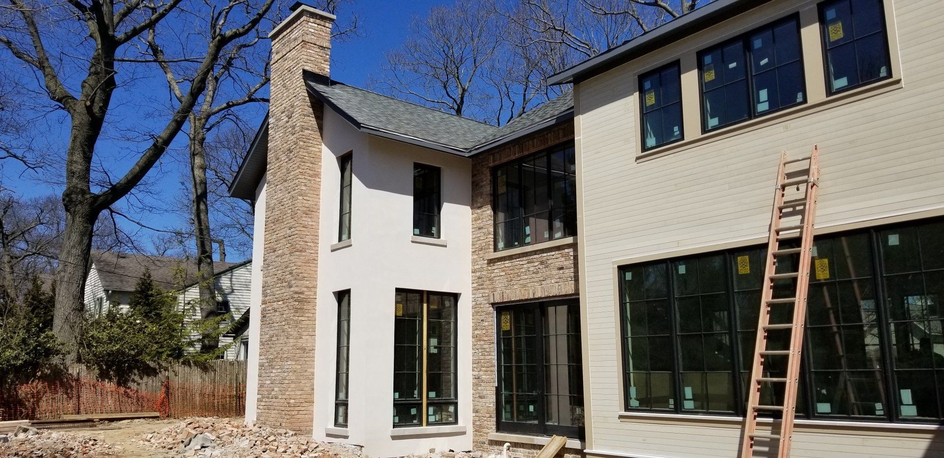 A large white house with a lot of windows is being built.