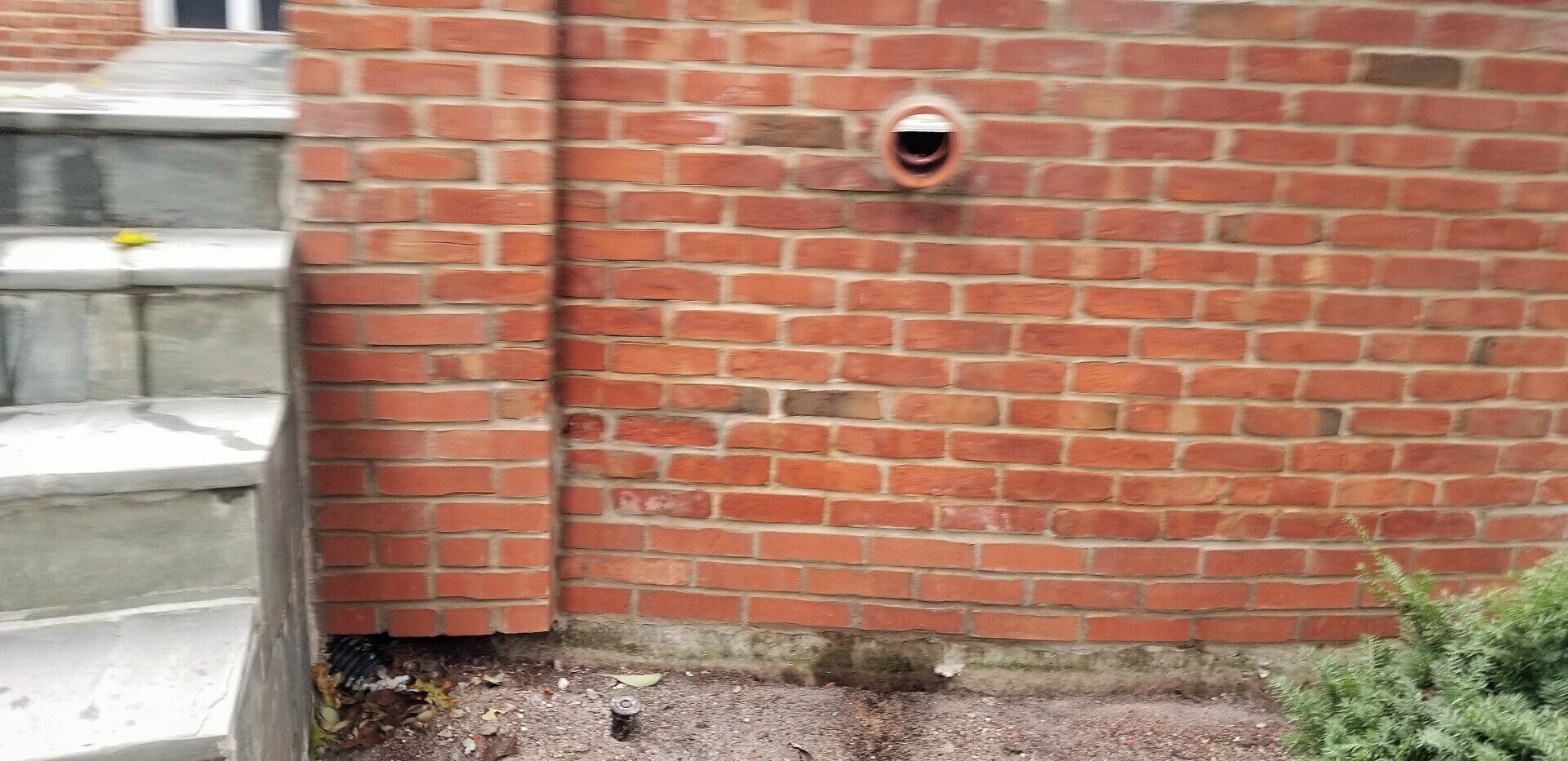 A brick wall with stairs leading up to it and a camera on it.