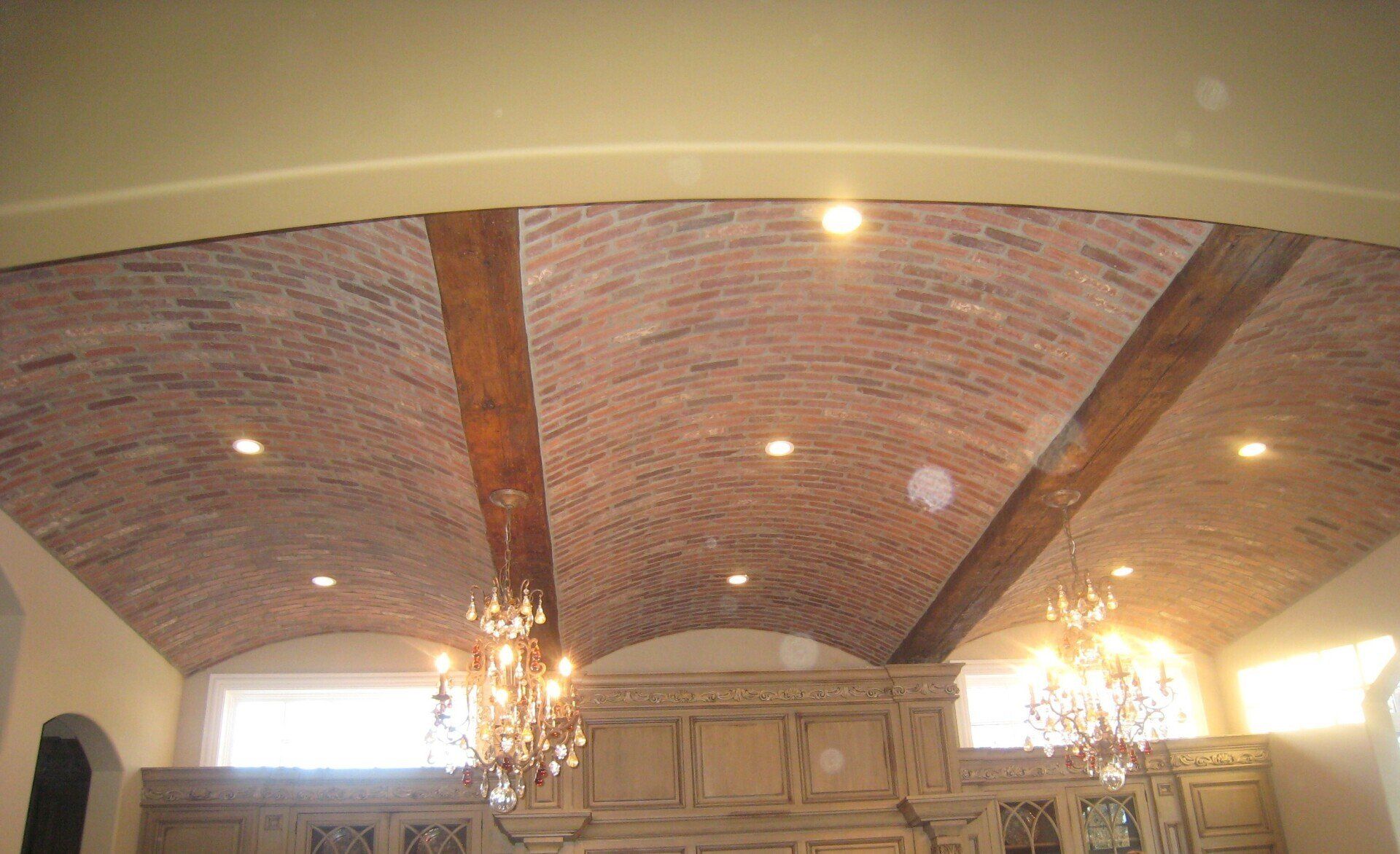 A room with a brick ceiling and a chandelier hanging from it