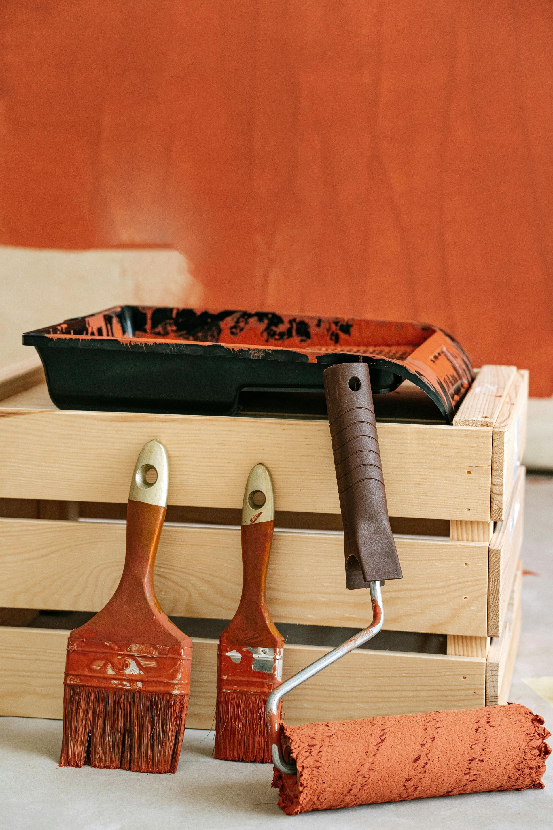 orange roller paint with paintbrush and wooden boxes