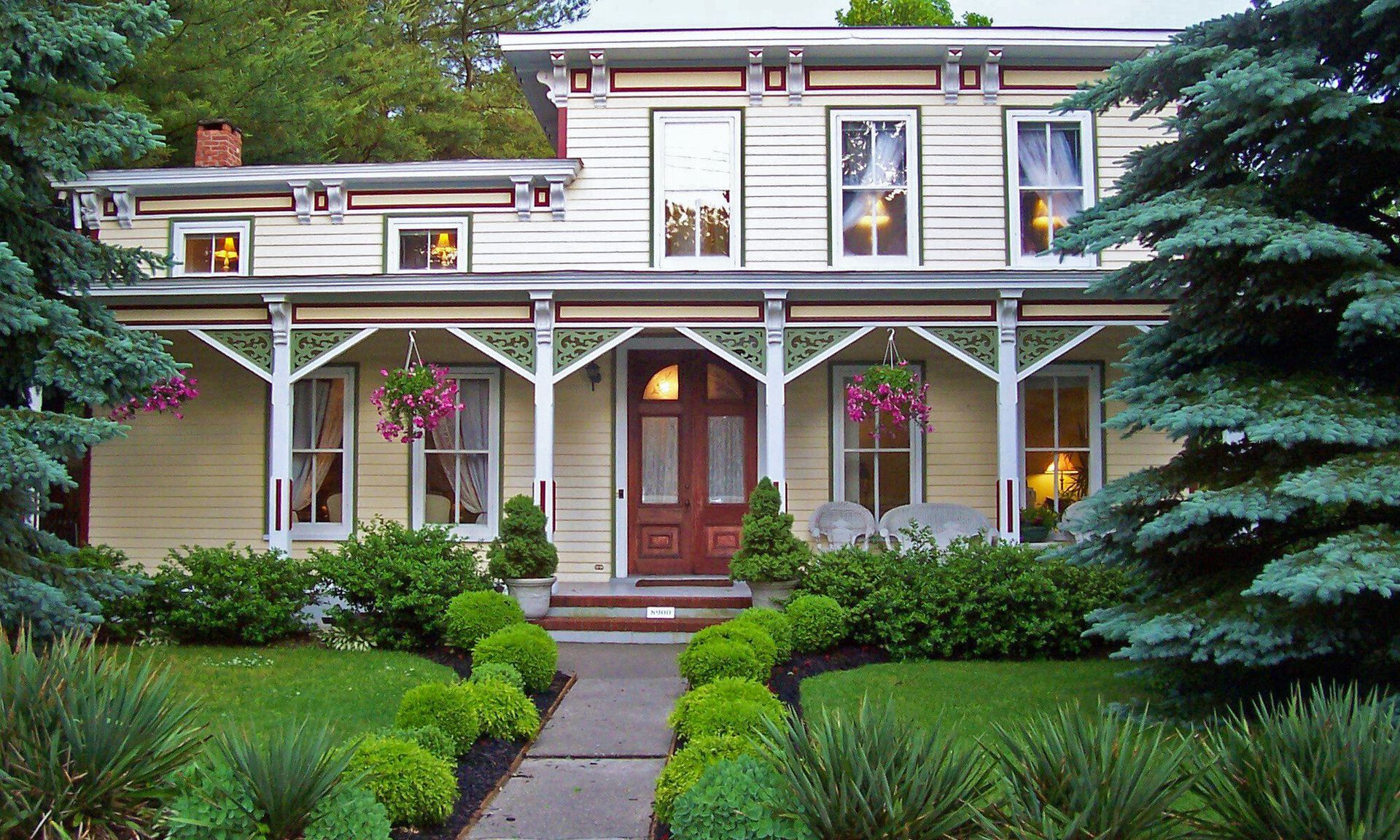 A house with a large porch and trees in front of it