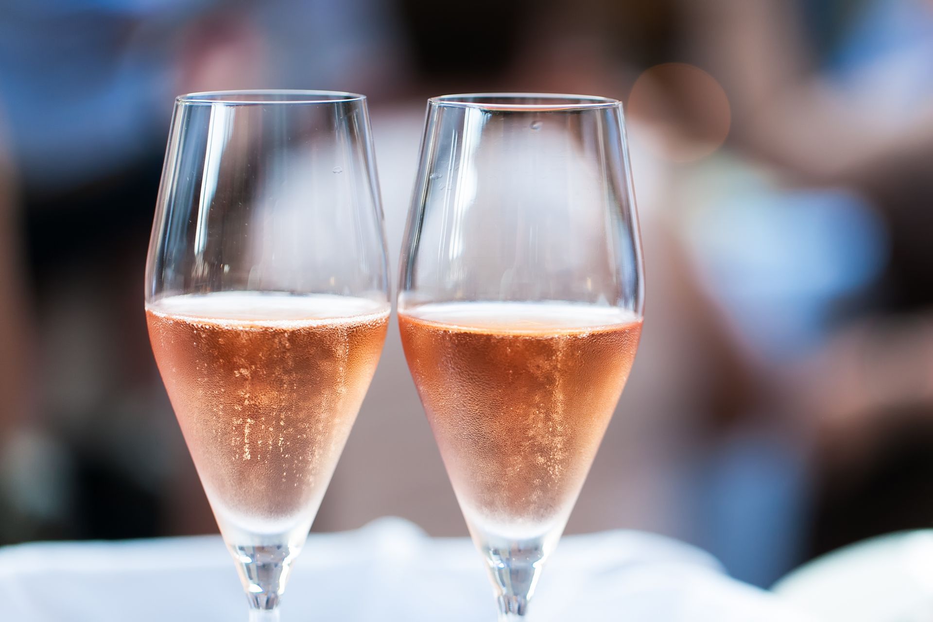 Two glasses of champagne on a table with a blurry background