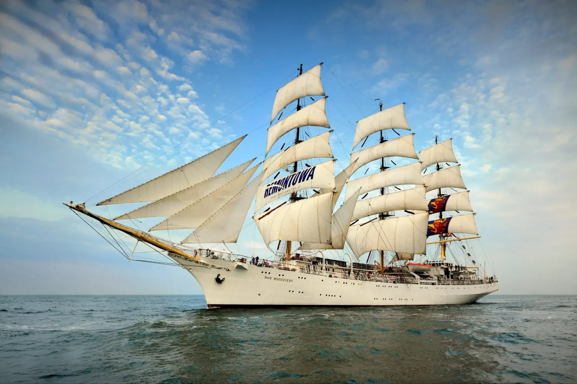 A large sailboat is floating on top of a body of water.