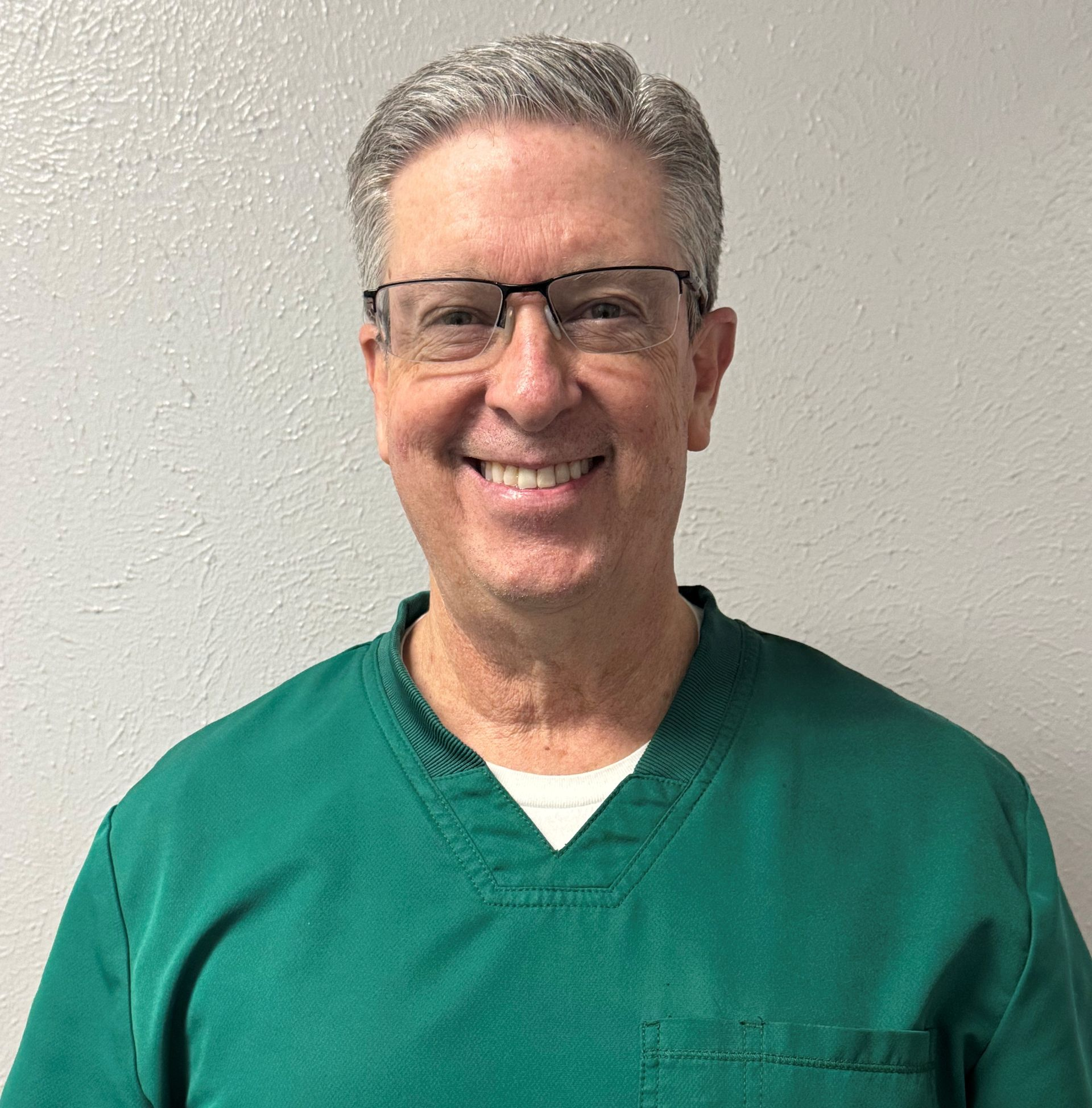 Doctor pointing at spine model, explaining to a patient in an office.