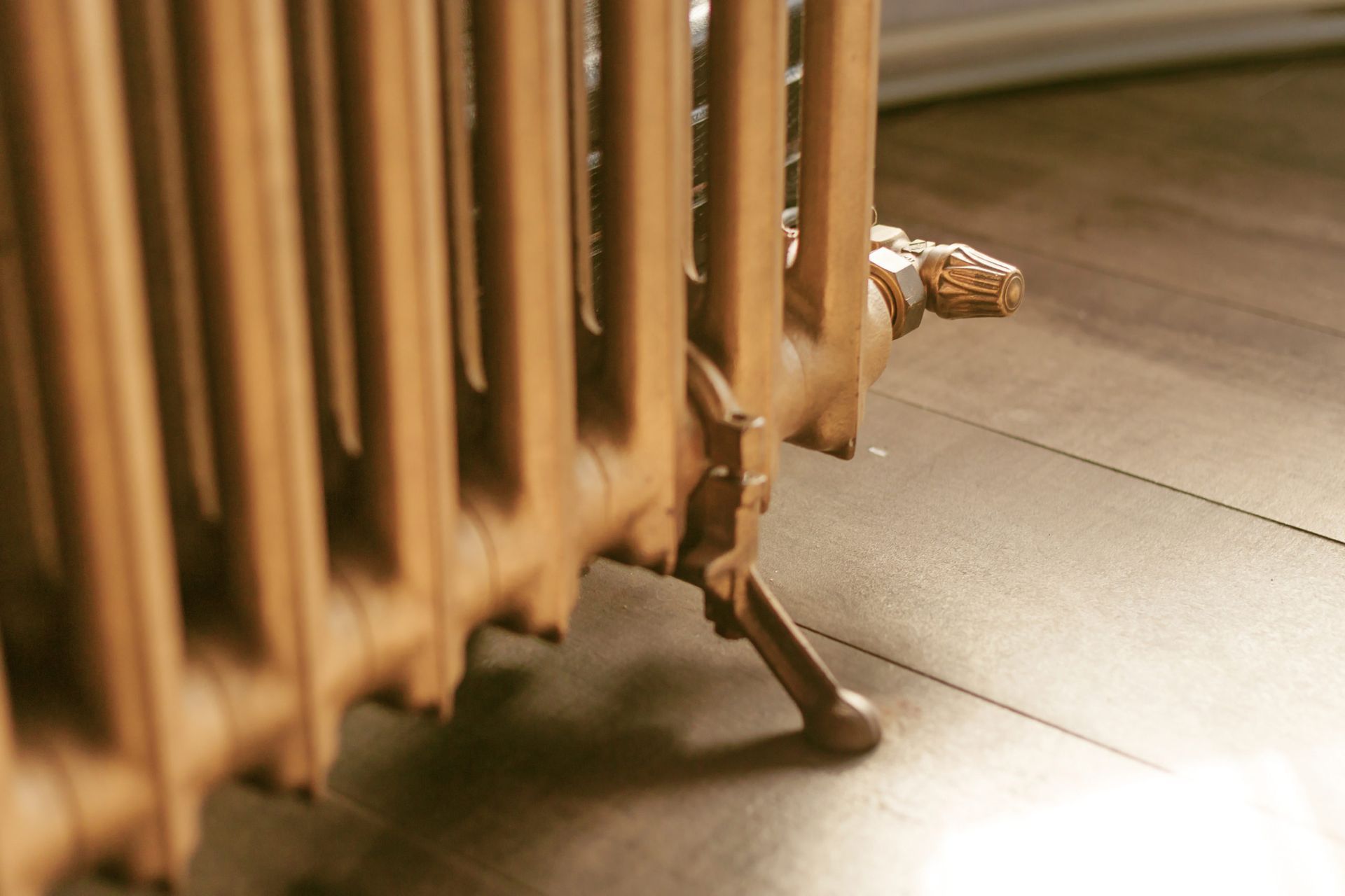 A close up of a radiator on a wooden floor.