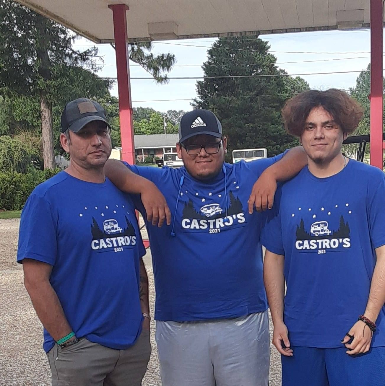 Three men in blue t-shirts that say 