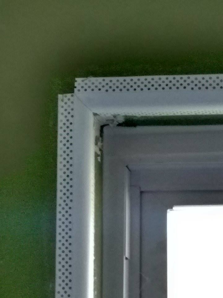 White corner bead installed around a window, with a green wall visible.