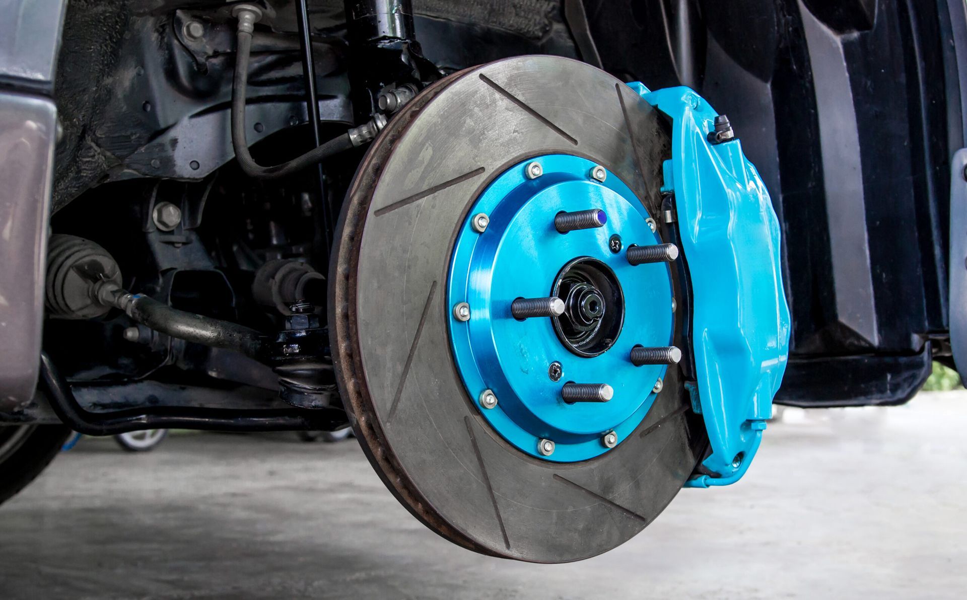 A close up of a blue brake caliper on a car.