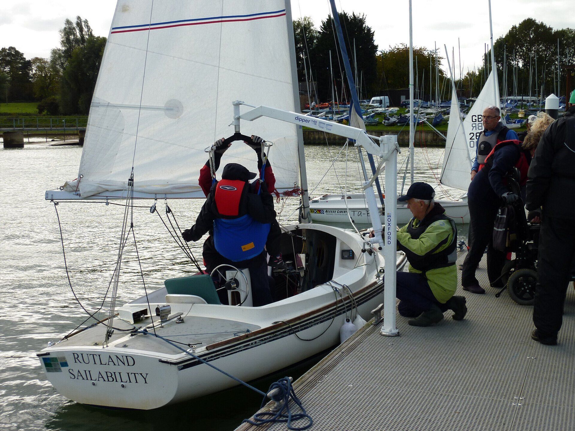disabled sailor hoisted into a sailing boat