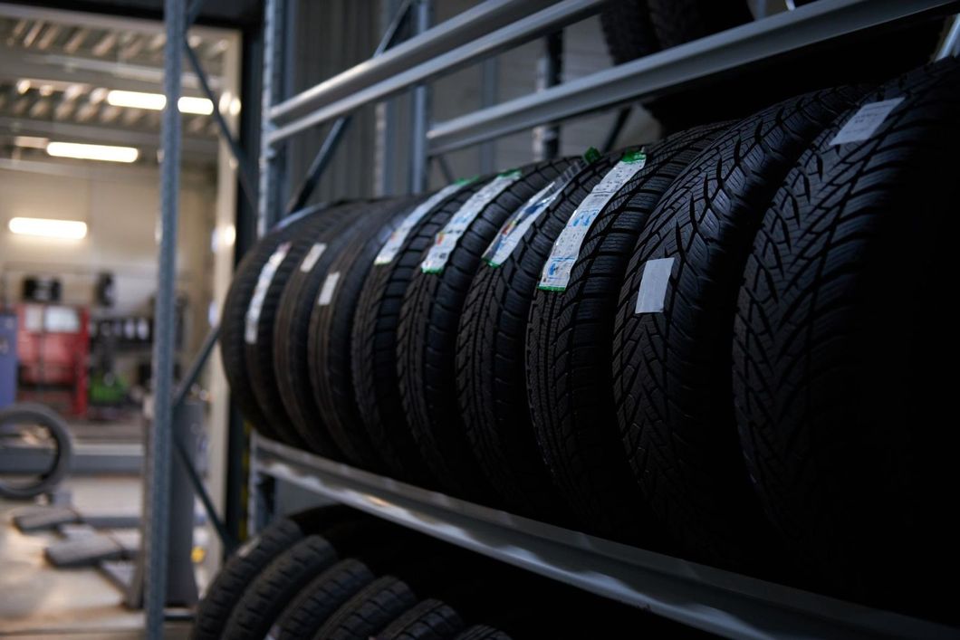 A row of tires are stacked on top of each other on a shelf.
