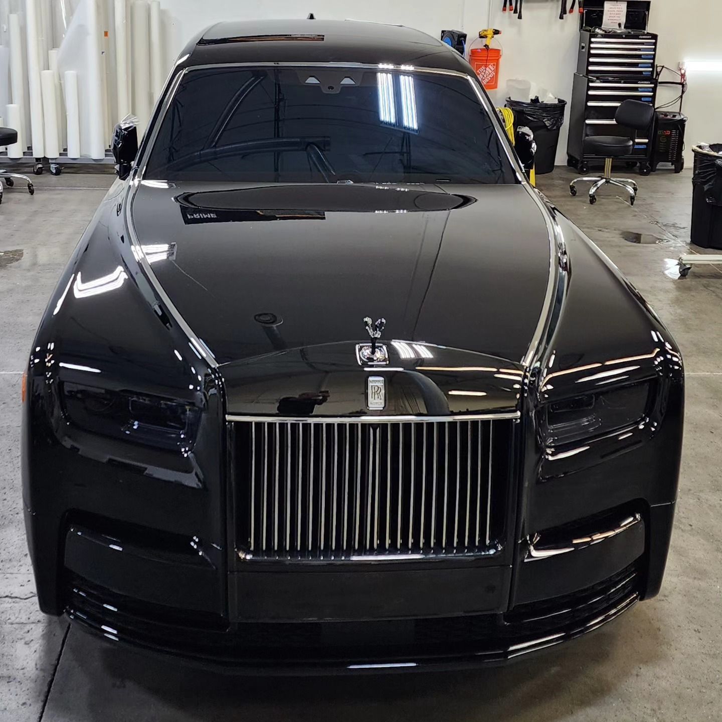A black rolls royce is parked in a garage