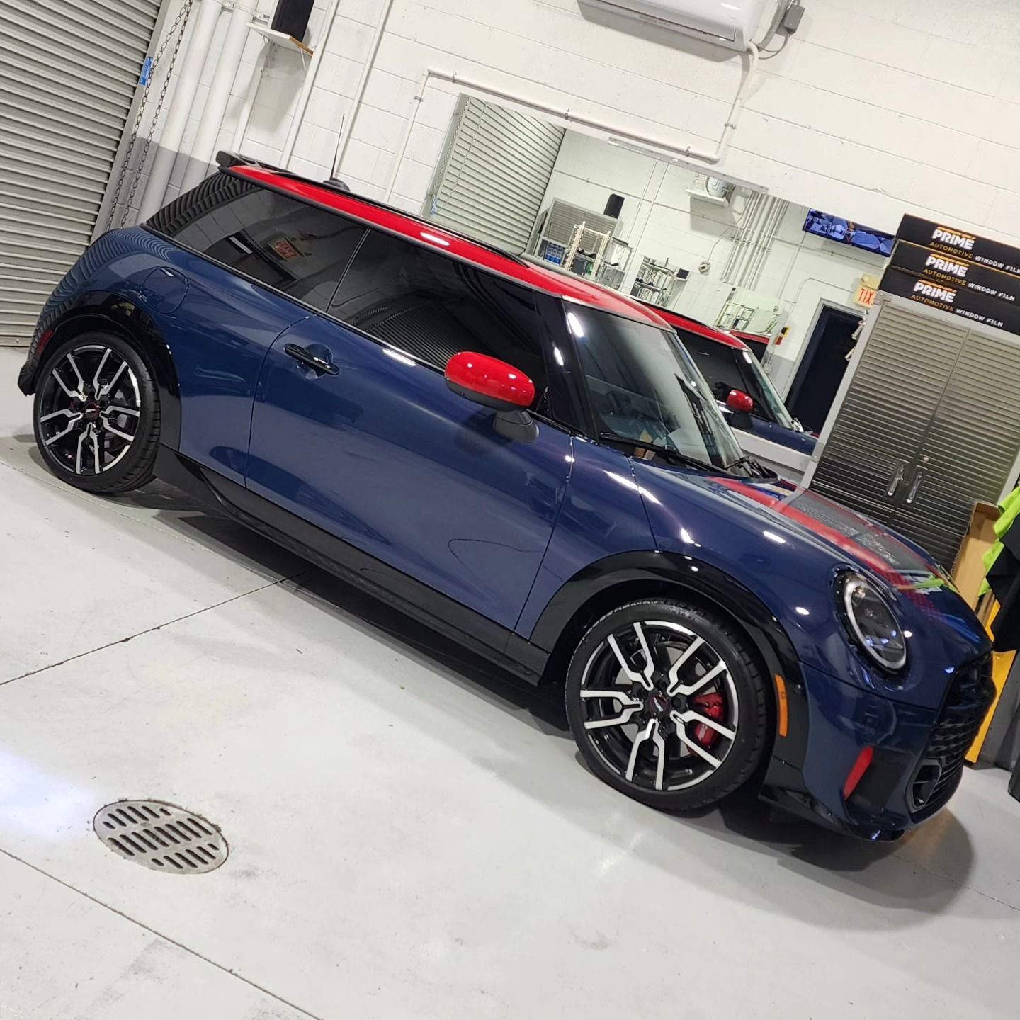 A blue mini cooper is parked in a garage.