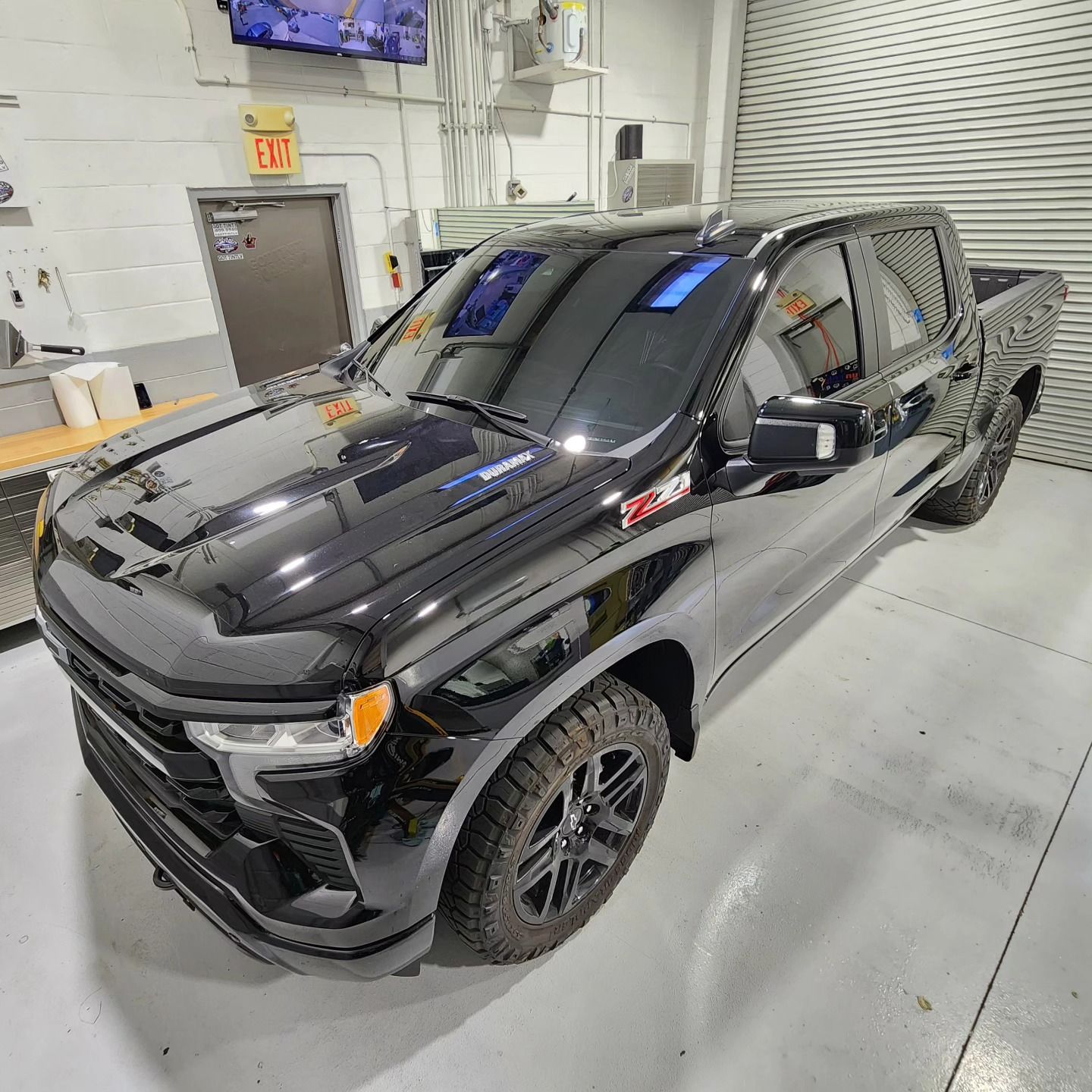 A black truck is parked in a garage.