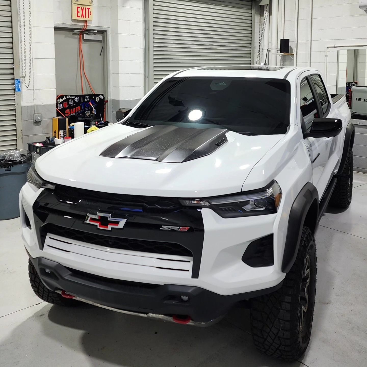 A white chevrolet truck is parked in a garage.