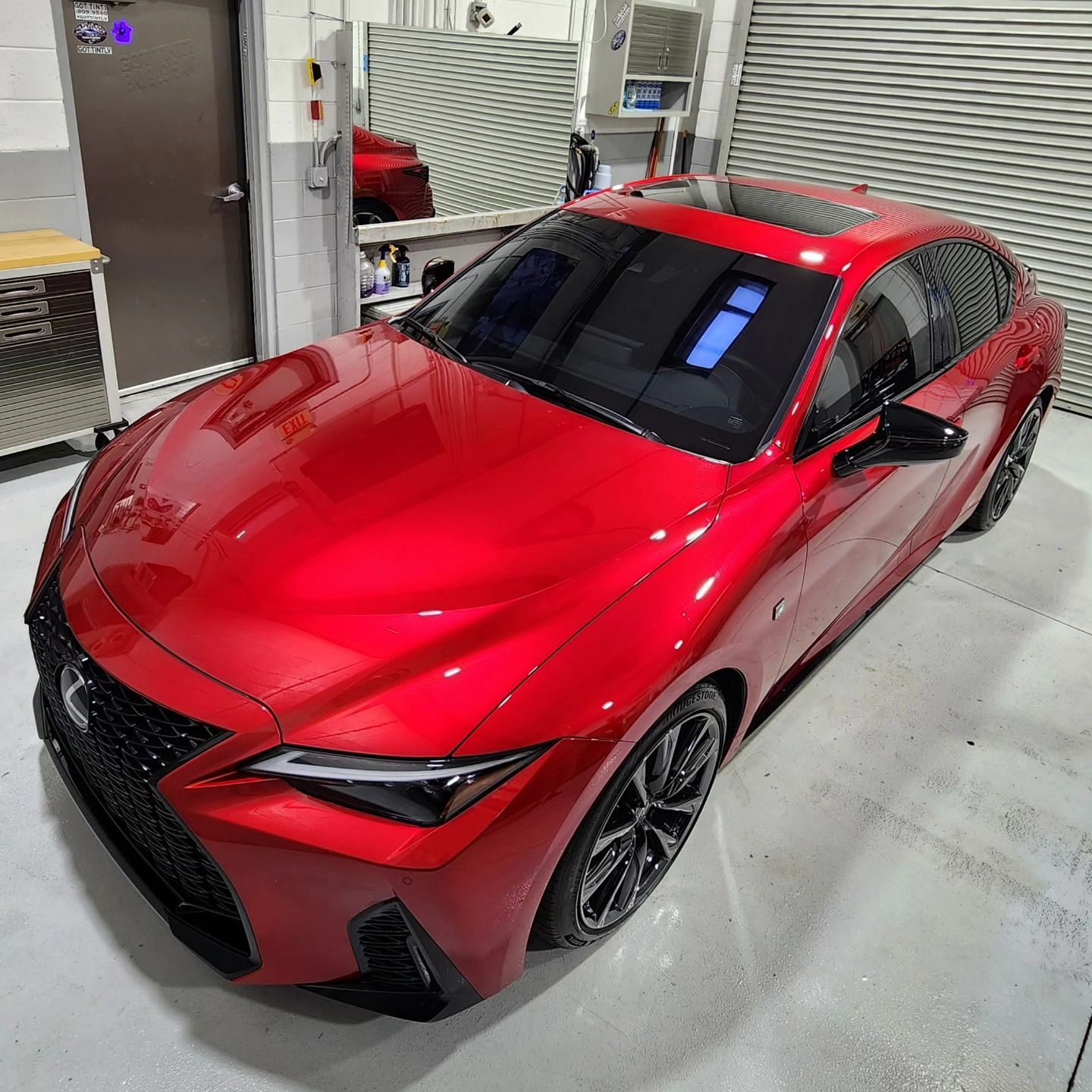 A red sports car is parked in a garage.