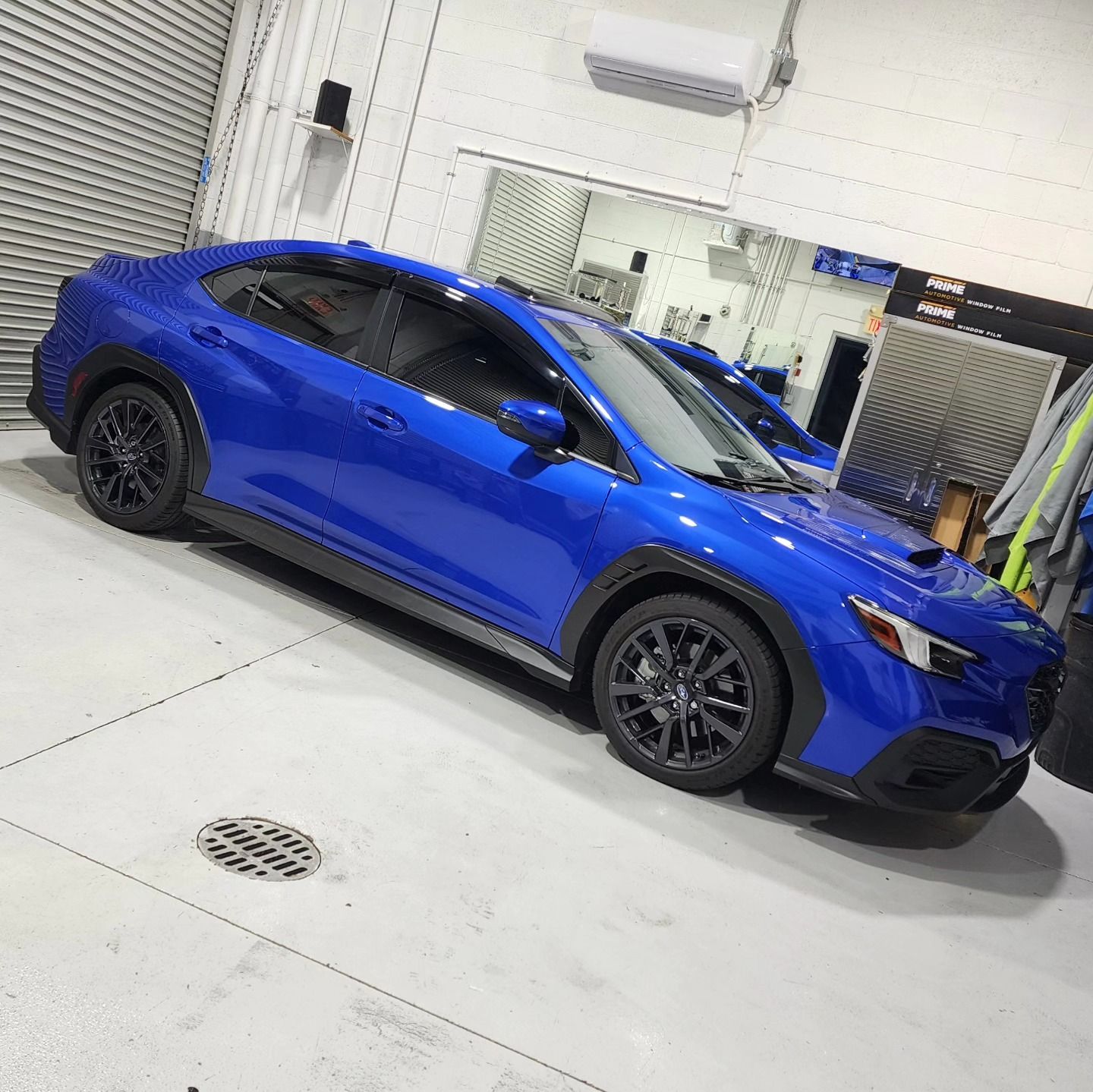 A blue subaru wrx sti is parked in a garage.