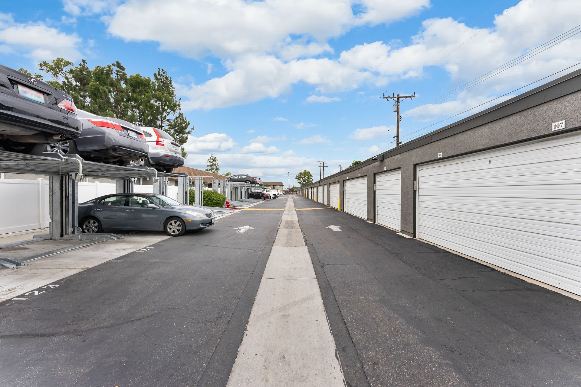 Parking area with garages on right and  vertical parking lights on the left