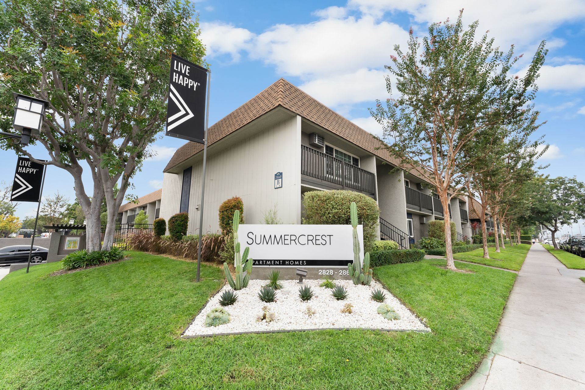 Exterior building with black flag, succulent landscaping, and Summer Crest sign