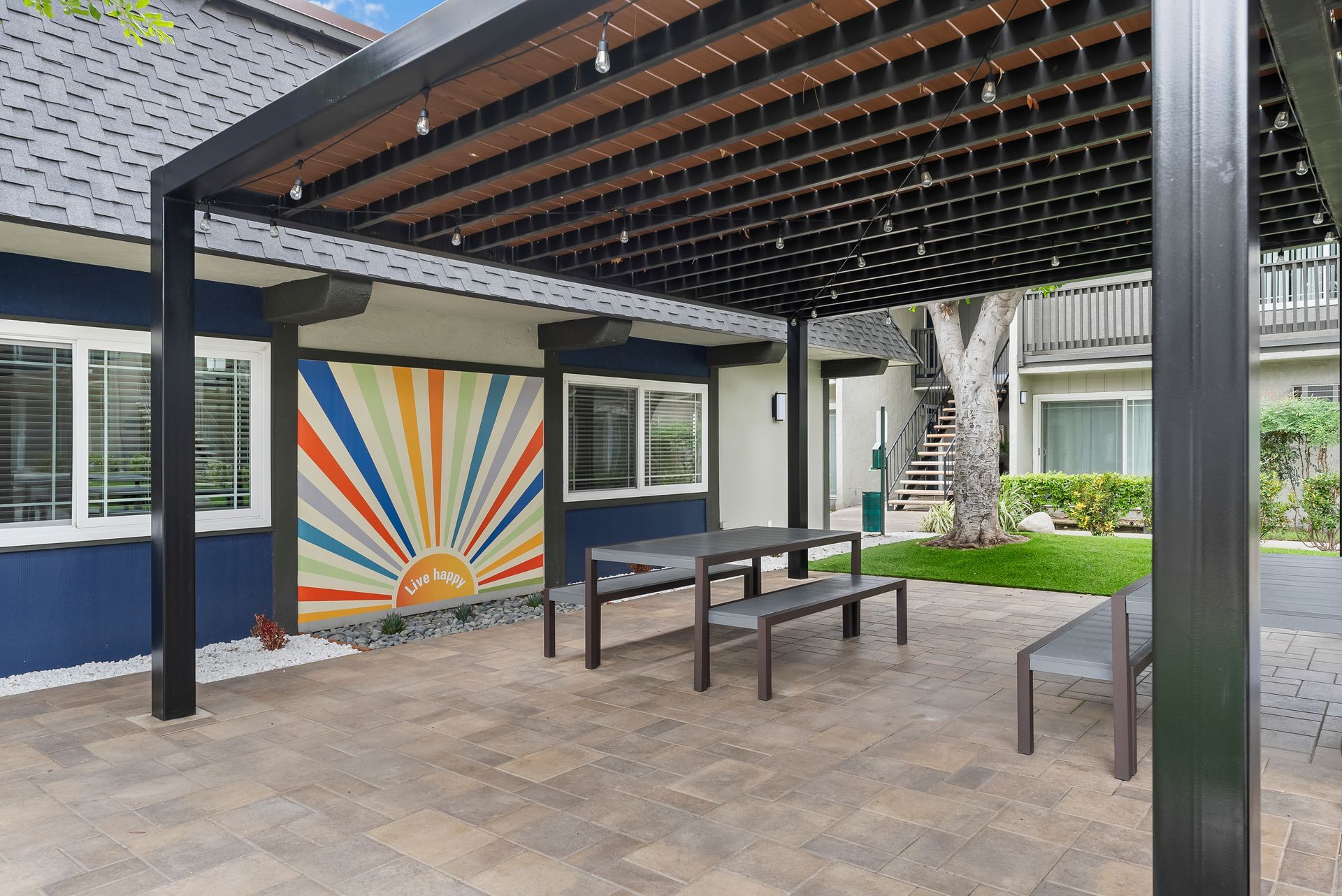 Picnic tables under canopy with rainbow picture wall