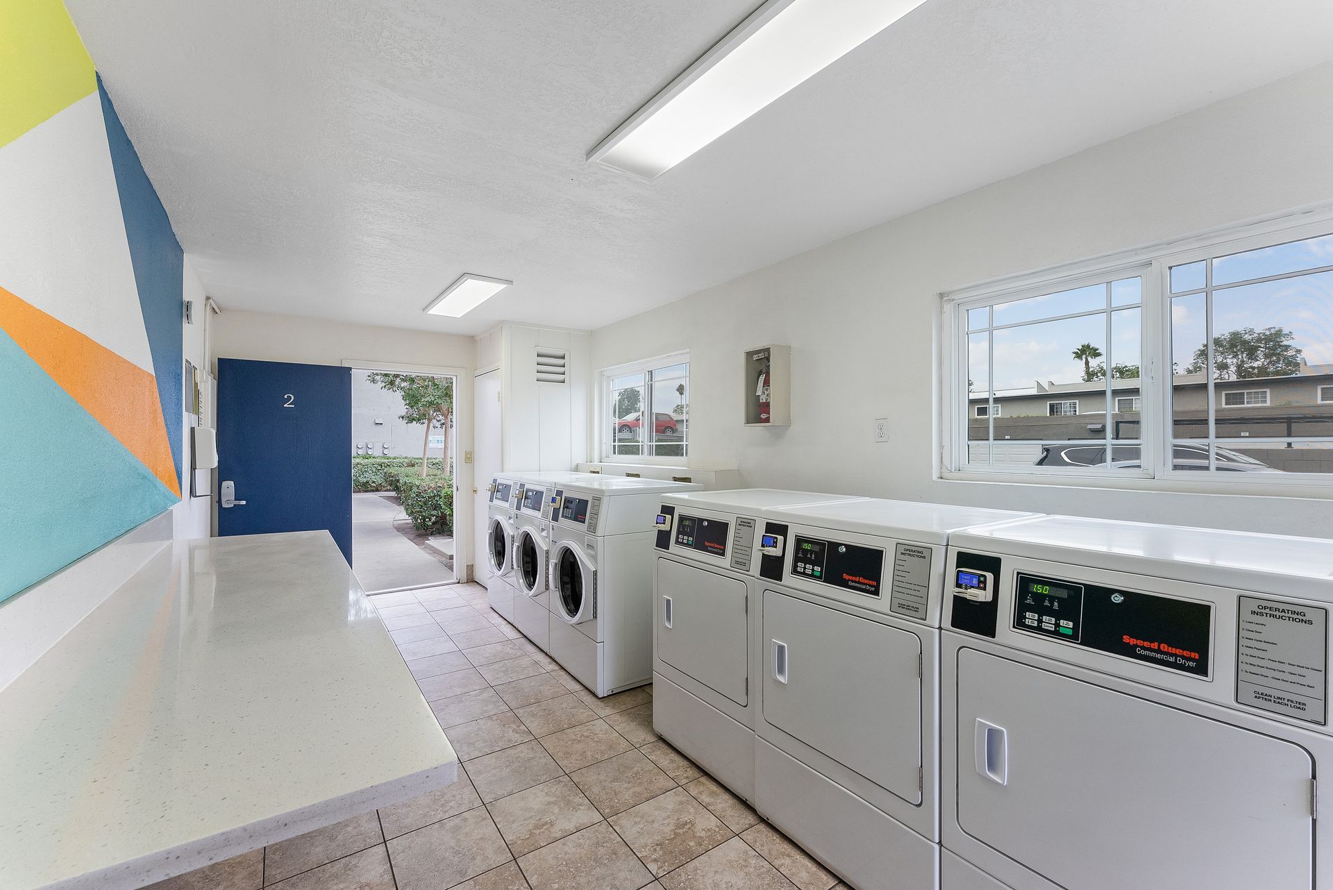 Community laundry room with three washers and three dryers