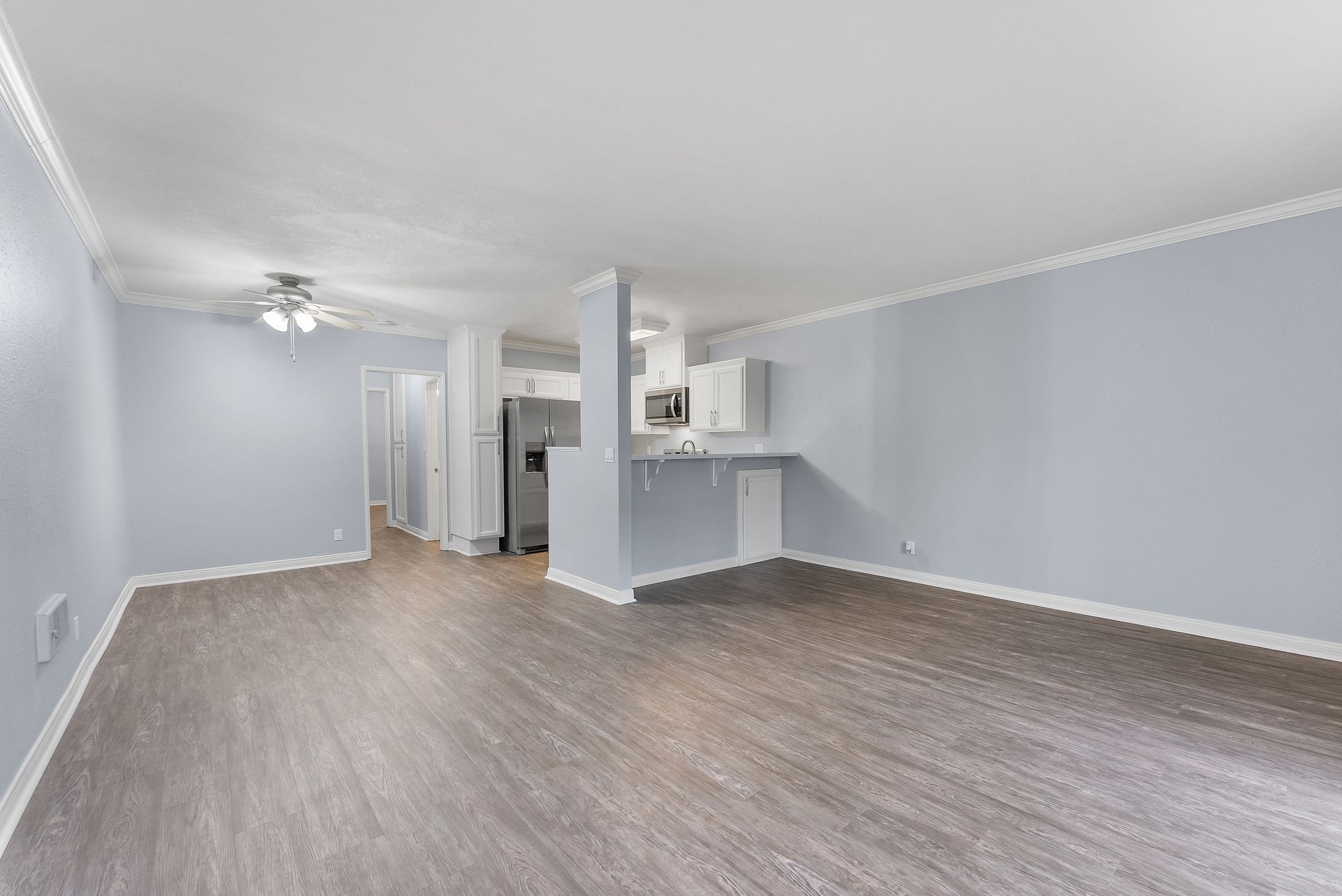 Wood floor living area with kitchen island in the background