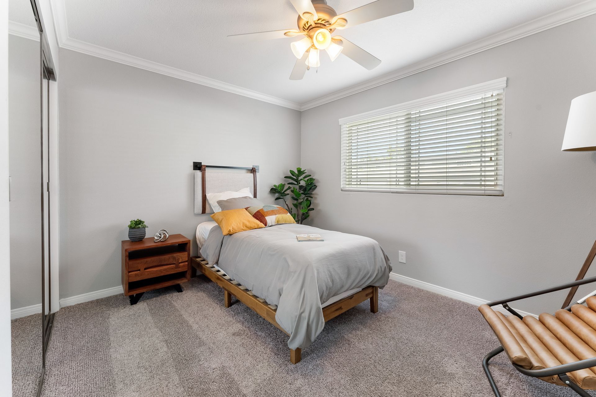 Bedroom with twin sized bed with window and ceiling fan