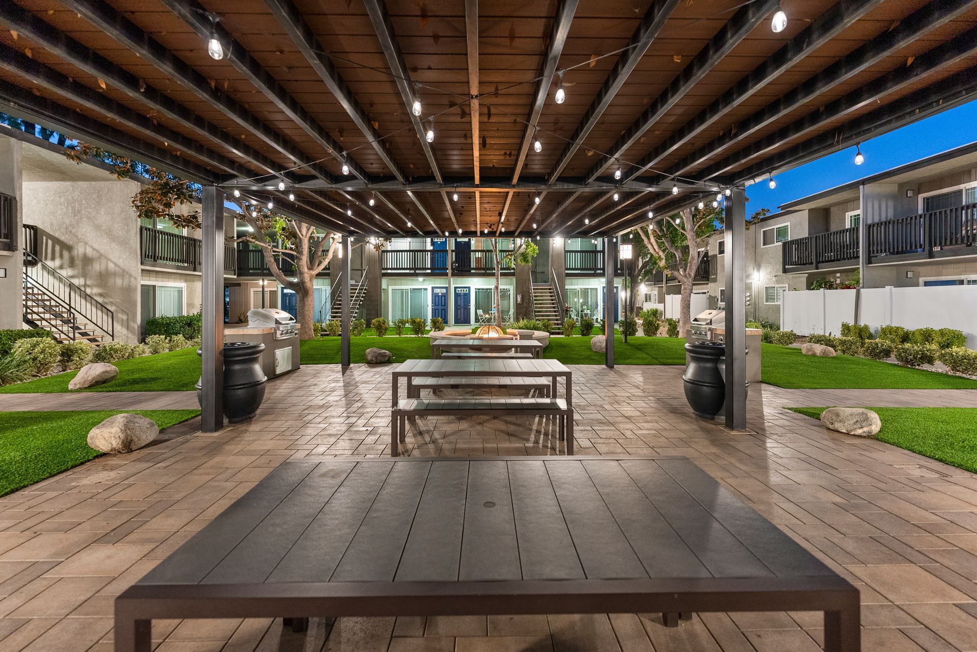 Under a canopy with picnic tables at twilight