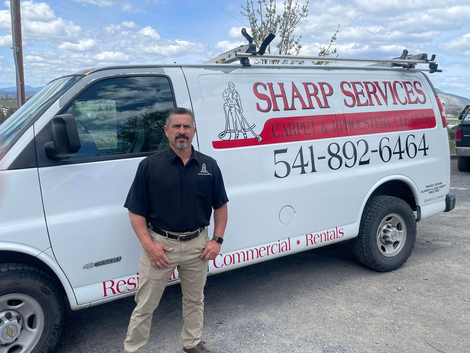 A person is cleaning a couch with a steam cleaner.