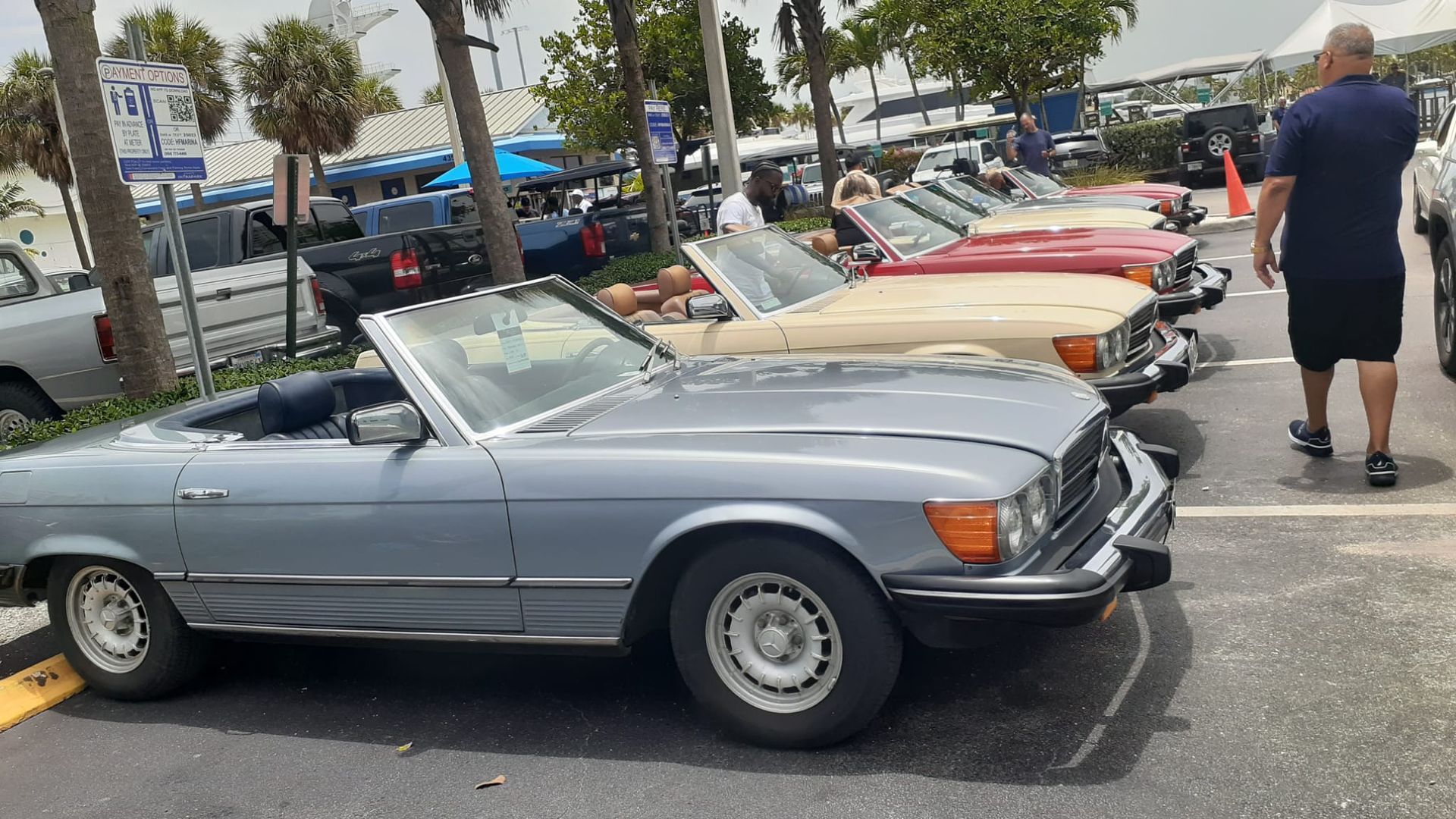 Several classic Mercedes-Benz convertibles parked outdoors, light blue one in the foreground.