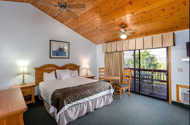 Bedroom with king bed, wooden ceiling, and balcony access.