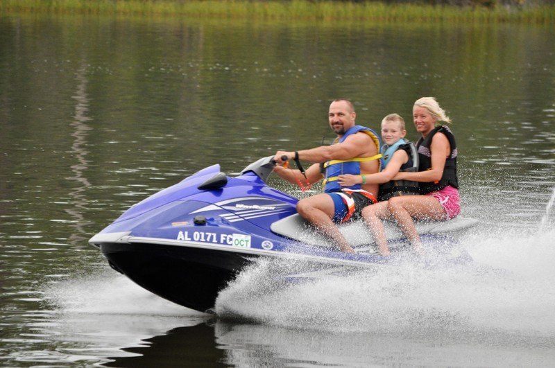A man and a woman are riding a jet ski on a lake.