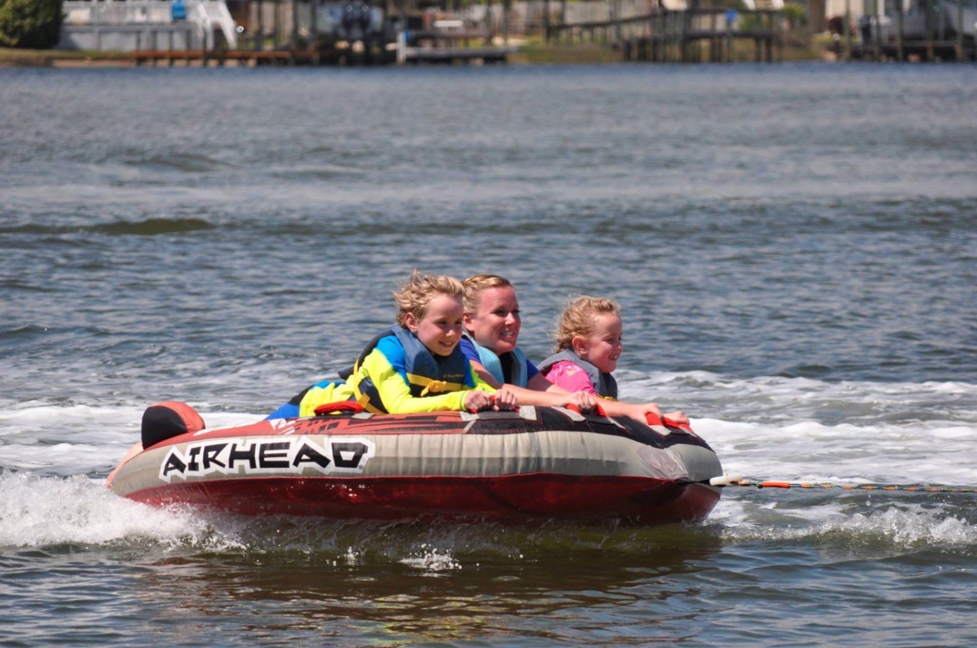 A group of people are riding a boat that says airhead on it