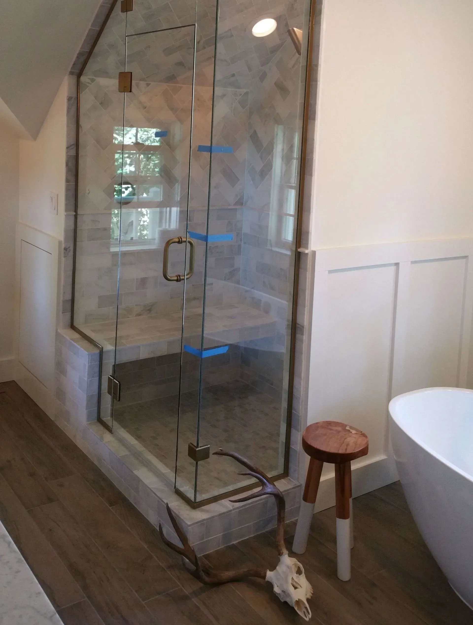 A bathroom with a bathtub and a shower with a glass door.