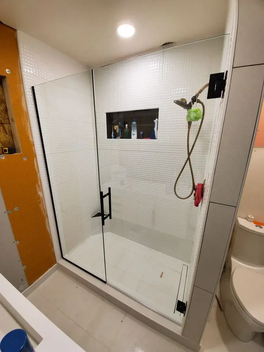 A bathroom with a walk in shower and a toilet