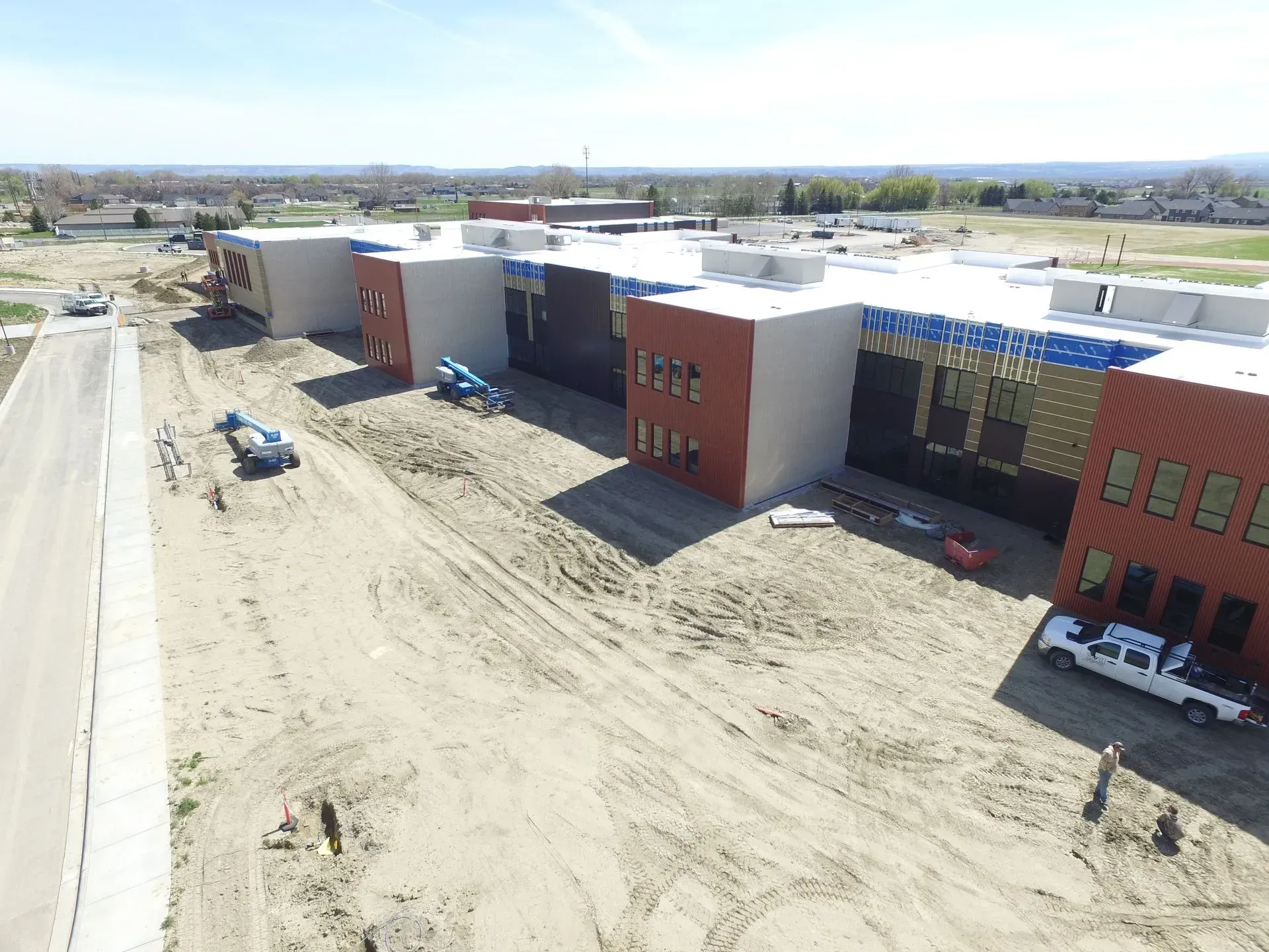 An aerial view of a building under construction with a white truck parked in front of it.